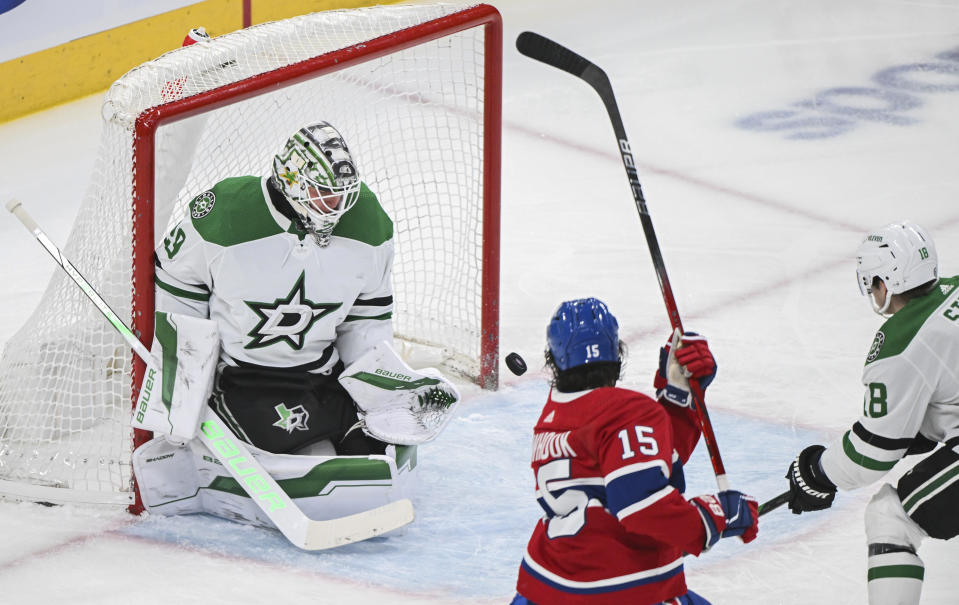 Montreal Canadiens' Alex Newhook (15) takes a shot on Dallas Stars goaltender Jake Oettinger as Stars' Sam Steel (18) defends during first period NHL hockey action in Montreal, Canada, Saturday, Feb. 10, 2024. (Graham Hughes/The Canadian Press via AP)