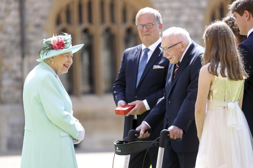 Britain's Queen Elizabeth talks with Captain Sir Thomas Moore and his family after awarding his knighthood during a ceremony at Windsor Castle in Windsor, England, Friday, July 17, 2020. Captain Sir Tom raised almost £33 million for health service charities by walking laps of his Bedfordshire garden. (Chris Jackson/Pool Photo via AP)