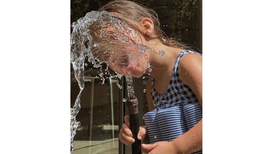 Khai played with the garden hose in a sweet summer snap