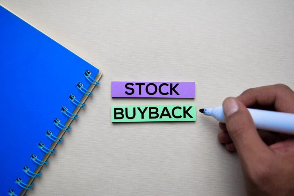 The words "Stock buyback" written on a notecard 