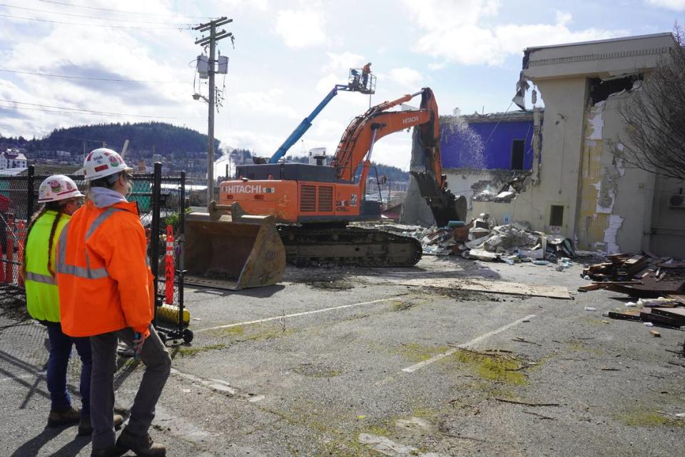 A Ram Construction crew member uses water to mitigate dust during demolition Tuesday, Marcy 14, at the Lighthouse Mission Ministries building at 910 Holly St. in Bellingham.