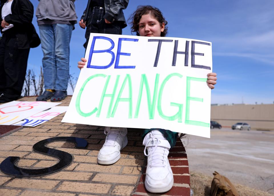 A student holds during a demonstration in honor of Nex Benedict outside Owasso High School on Monday.