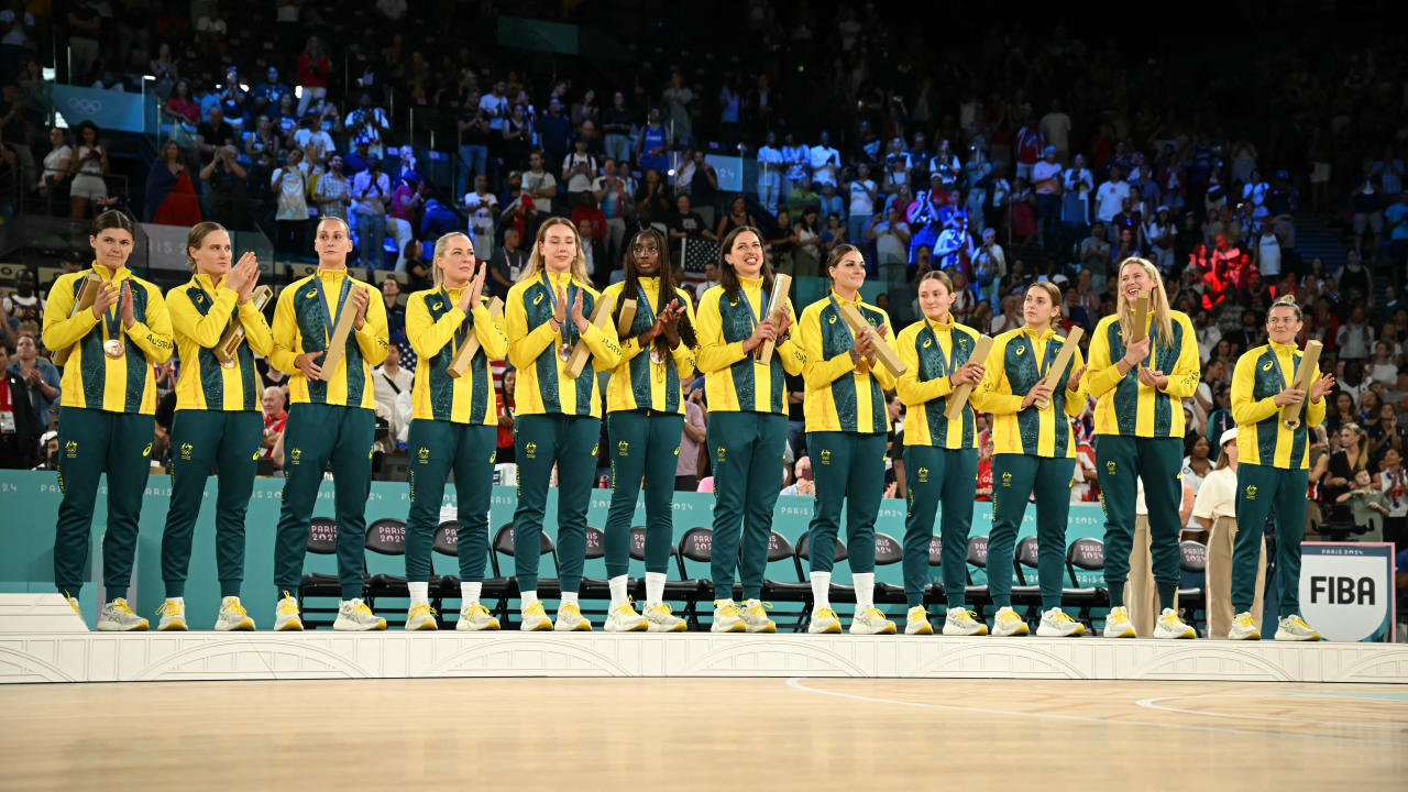 Bronze medallists Australia's players celebrate on the podium after the women's Bronze Medal basketball match between Belgium and Australia during the Paris 2024 Olympic Games at the Bercy  Arena in Paris on August 11, 2024. (Photo by Paul ELLIS / AFP) (Photo by PAUL ELLIS/AFP via Getty Images)