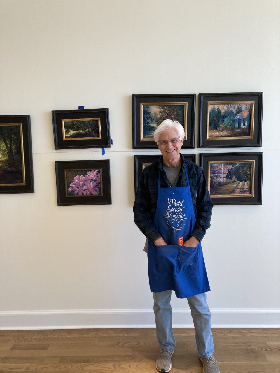 Artist Charles Peer stands in front of his exhibit at Arts on Main.