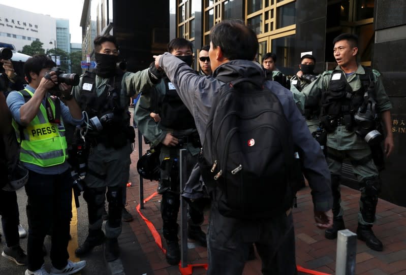 A pro-democratic protester approaches police officers outside the Polytechnic University (PolyU) in Hong Kong