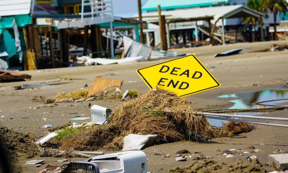 A street sign was knocked almost flat, covered in march vegetation and sand, during the passage of Hurricane Ida on Grand Isle, Louisiana.