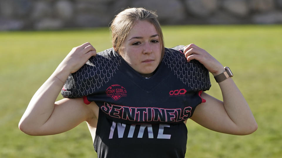 Sam Gordon puts on her shoulder pads, Oct. 20, 2020, in Herriman, Utah. Gordon was the only girl in a tackle football league when she started playing the game at age 9. Now, Gordon hopes she can give girls a chance to play on female-only high school teams through a lawsuit. (AP Photo/Rick Bowmer)