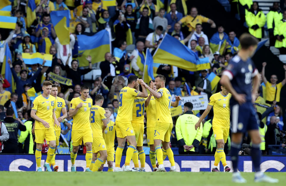 Ukraine's Roman Yaremchuk celebrates with teammates after scoring his side's second goal during the World Cup 2022 qualifying play-off soccer match between Scotland and Ukraine at Hampden Park stadium in Glasgow, Scotland, Wednesday, June 1, 2022. (AP Photo/Scott Heppell)