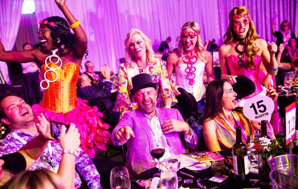 David and Kim Martin, center, celebrate a winning bid during the SWFL Wine & Food Fest at Suncoast Credit Union Arena in Fort Myers on Saturday, Jan. 20, 2024. The auction raised over $2 million. Congratulating them at center top is Sandra Stilwell-Youngquist.