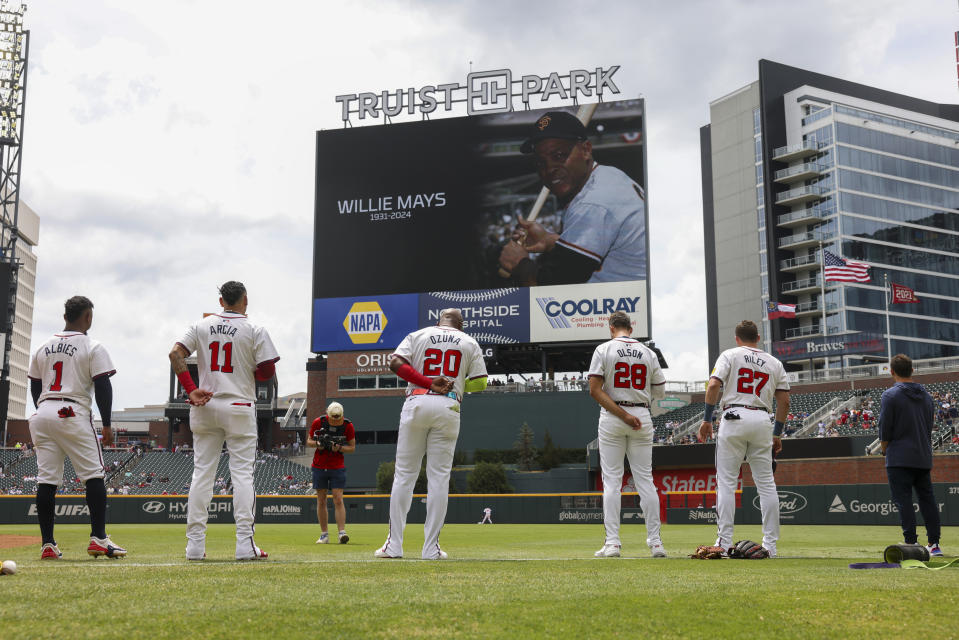 Atlanta Braves players stand for a moment of silence in observance of the death of Baseball Hall of Fame Willie Mays before a baseball game against the Detroit Tigers at Truist Park, Wednesday, June 19, 2024, in Atlanta. (Jason Getz/Atlanta Journal-Constitution via AP)