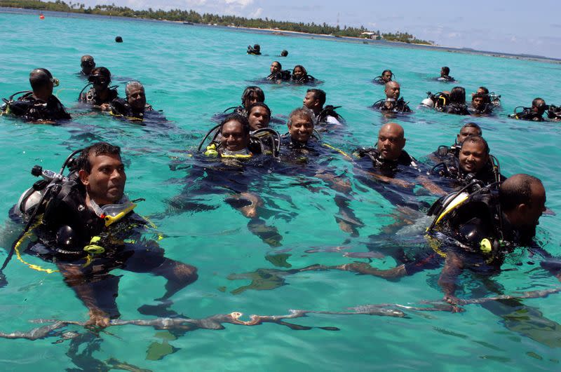 FILE PHOTO: Members of the Maldives government swim to attend the first underwater cabinet meeting in the Maldives