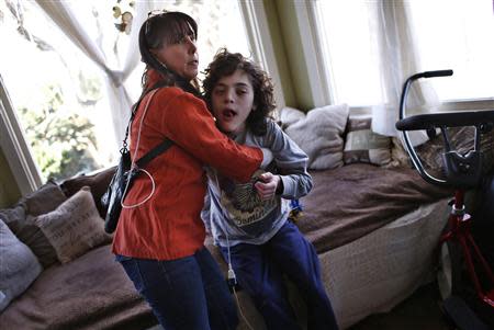 Missy Miller holds her epileptic son Oliver (R) in their home at Atlantic Beach, New York January 7, 2014. REUTERS/Mike Segar