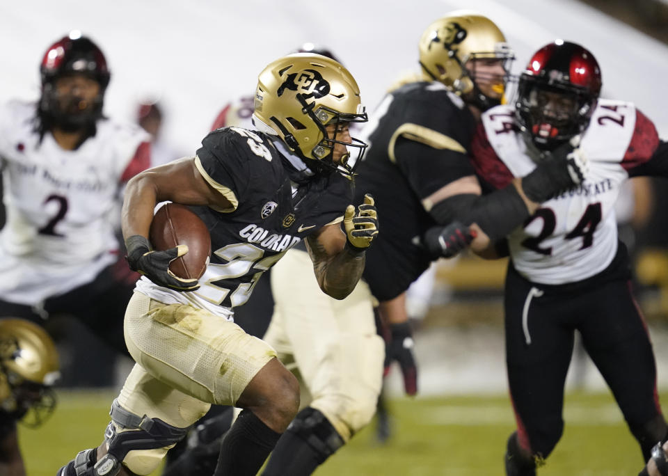 Colorado running back Jarek Broussard, front, runs for a short gain as San Diego State linebacker Segun Olubi pursues during the second half of an NCAA college football game Saturday, Nov. 28, 2020, in Boulder, Colo. (AP Photo/David Zalubowski)