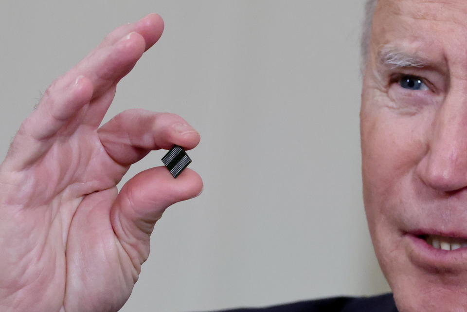 U.S. President Joe Biden delivers holds a semiconductor chip as he speaks prior to signing an executive order, aimed at addressing a global semiconductor chip shortage, in the State Dining Room at the White House in Washington, U.S., February 24, 2021. REUTERS/Jonathan Ernst TPX IMAGES OF THE DAY