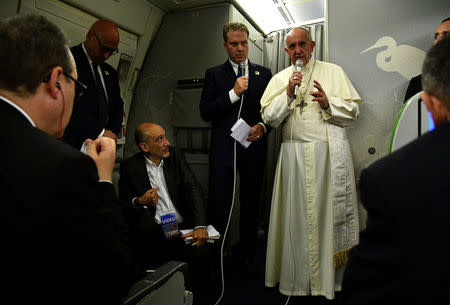 Pope Francis gestures during a news conference on board of the plane during his flight back from a trip to Myanmar and Bangladesh, December 2, 2017. REUTERS/Vincenzo Pinto/Pool