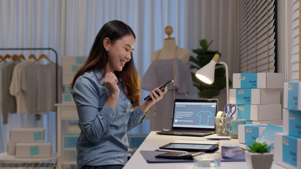 Young attractive beautiful female entrepreneur looking at a smartphone in an office environment