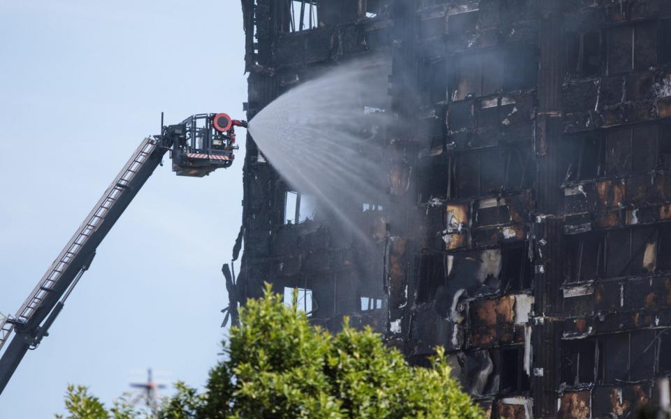 Water is sprayed by fire fighters on to the burning 24 storey residential Grenfell Tower block in Latimer Road, West London on June 14, 2017 - Credit: Getty