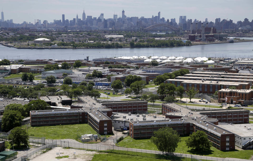 FILE - In a June 20, 2014, file photo, the Rikers Island jail complex stands in New York with the Manhattan skyline in the background. The nation’s jails and prisons are on high alert about the prospect of the new coronavirus spreading through their vast inmate populations. (AP Photo/Seth Wenig, File)