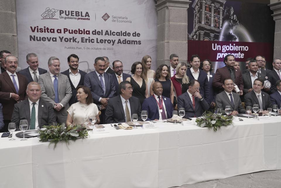 The Mayor of New York City Eric Adams, center, poses with local businessmen and dignitaries during an event at the former Municipal Palace in Puebla, Mexico, Thursday, Oct. 5, 2023. Adams is visiting the city, just outside the nation's capital, as part of a four-day trip to Latin America which he hopes will ease the burden of asylum seekers on New York. (AP Photo/Fernanda Pesce)