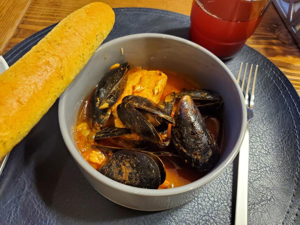 bowl of stew with clams and a side of bread