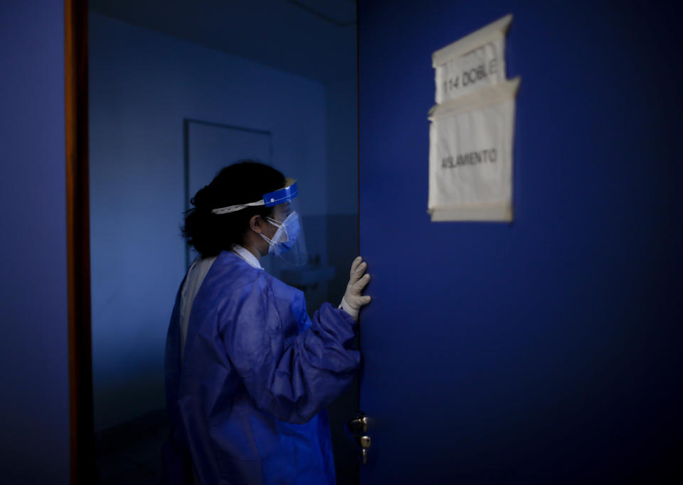 Dr. Veronica Verdino enters in a room to check on COVID-19 patients at Llavallol Dr. Norberto Raúl Piacentini Hospital in Lomas de Zamora, Argentina, Saturday, May 8, 2021. A little over a year ago, before the pandemic hit Argentina, the 31-year-old doctor did not imagine that she would be performing so many intubations. (AP Photo/Natacha Pisarenko)