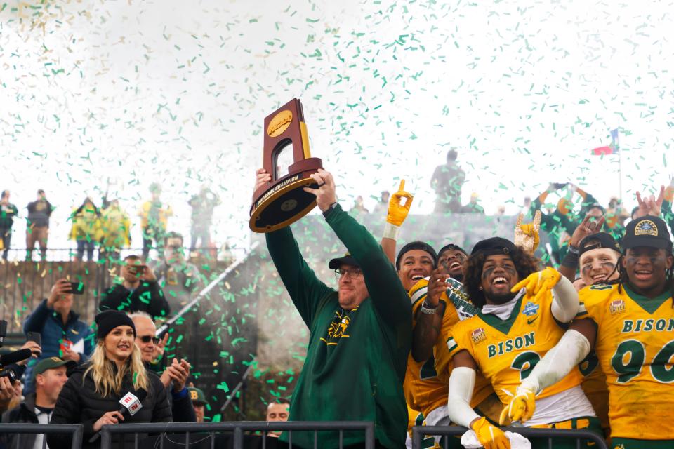 North Dakota State head coach Matt Entz holds up the championship trophy as he celebrates with linebacker Jasir Cox (3) and defensive end Tony Pierce (90) after the FCS Championship NCAA college football game against Montana State, Saturday, Jan. 8, 2022, in Frisco, Texas.  (AP Photo/Michael Ainsworth)