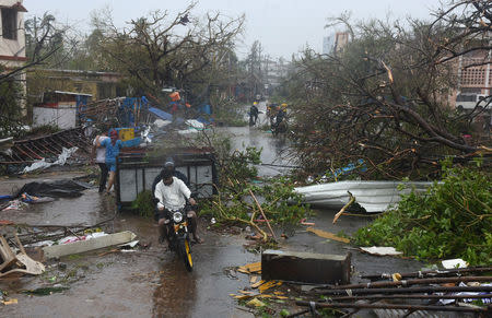 People move through debris on a road after Cyclone Fani hit Puri, in the eastern state of Odisha, India, May 3, 2019. REUTERS/Stringer