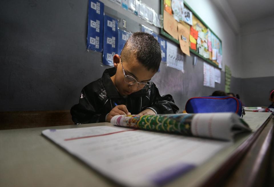 In this picture taken on Wednesday, March 5, 2014, Syrian refugee student Mohammed Jomaa, 9, studies in a mixed Lebanese-Syrian students classroom at a Lebanese public school in Beirut, Lebanon. Of about 1.2 million children who have fled the country and now live as refugees in camps and overwhelmed communities in neighboring countries, 300,000 Syrian children are out of school in Lebanon, along with some 93,000 in Jordan, 78,000 in Turkey, 26,000 in Iraq and 4,000 in Egypt, according to UNICEF. The number of Syrian children out of school are likely higher since UNICEF data does not cover children, whose parents have not registered as refugees with the U.N. (AP Photo/Hussein Malla)