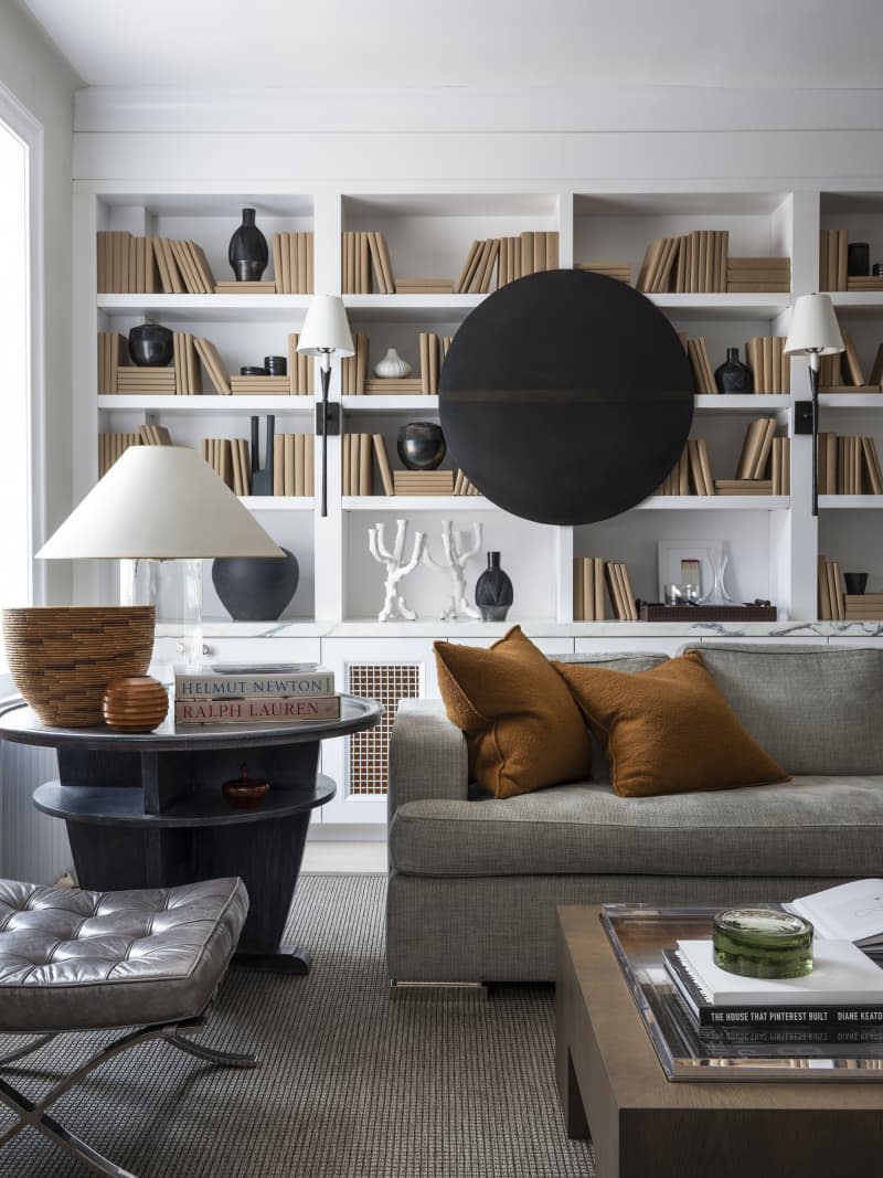 Living room with gray sofa and wall of white built in bookshelves