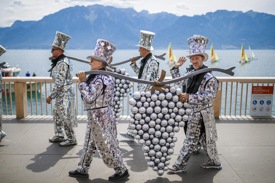 People take part of the "Fete des Vignerons" (winegrowers' festival in French), parade during the official opening parade prior to the first representation and crowning ceremony in Vevey, Switzerland, Thursday, July 18, 2019. Organized in Vevey by the brotherhood of winegrowers since 1979, the event will celebrate winemaking from July 18 to August 11 this year. (Valentin Flauraud/Keystone via AP)