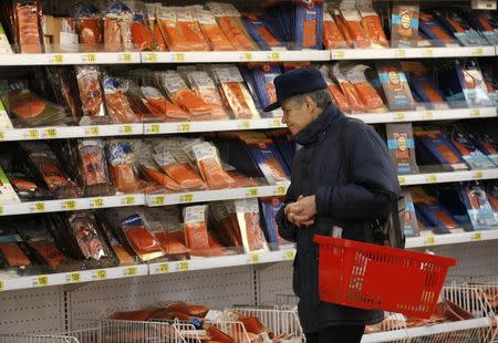 A customer stands in front of shelves at the fish department of a hypermarket of French grocery retailer Auchan in Moscow, January 15, 2015. REUTERS/Maxim Zmeyev