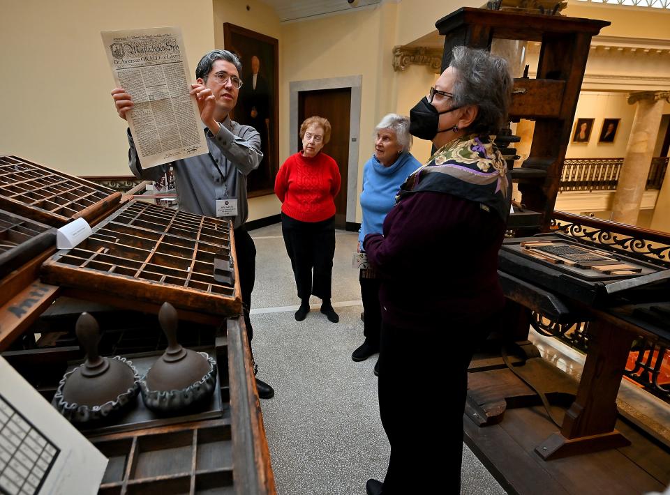 John J. Garcia, director of scholarly programs and partnerships, displays a copy of the Massachusetts Spy that was created in 1775 by founder Isaiah Thomas on the same printing press before him during a tour at the American Antiquarian Society in Worcester.