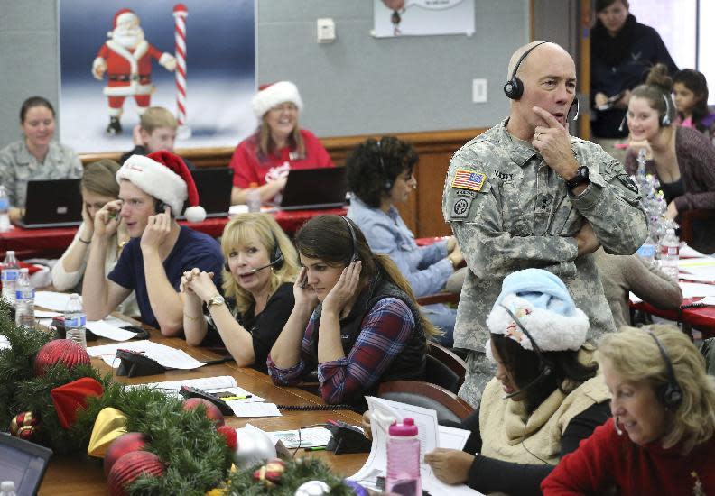 FILE - In this Dec. 24, 2014, file photo, NORAD and U.S. Northern Command (USNORTHCOM) Chief of Staff Maj. Gen. Charles D. Luckey joins other volunteers taking phone calls from children around the world asking where Santa is and when he will deliver presents to their homes, inside a phone-in center during the annual NORAD Tracks Santa Operation, at the North American Aerospace Defense Command, at Peterson Air Force Base, Colo. The wildly popular NORAD Tracks Santa operation is launching its 61st run at Peterson Air Force Base, Colo. Volunteers will answer phone calls and emails and post updates about Santa's storybook world tour on Facebook and Twitter. (AP Photo/Brennan Linsley, File)