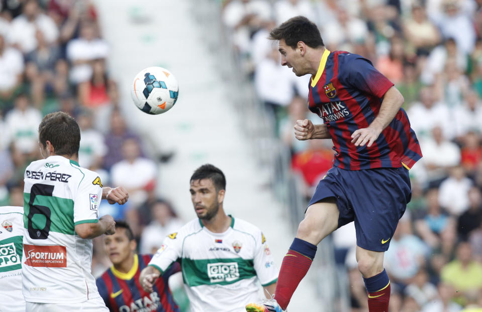 Barcelona's Lionel Messi from Argentina, right, heads the ball past Elche's Ruben Perez del Marmol during a Spanish La Liga soccer match at the Martinez Valero stadium in Elche, Spain, on Sunday, May 11, 2014.(AP Photo/Alberto Saiz)