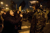 CLARIFIES WOMAN WAS TALKING TO POLICEMAN - In this Saturday, Jan. 11, 2020 photo, released by Iranian Students' News Agency, ISNA, a woman attending a candlelight vigil to remember the victims of the Ukraine plane crash, talks to a policeman, at the gate of Amri Kabir University in Tehran, Iran. Security forces deployed in large numbers across the capital, Tehran, on Sunday, expecting more protests after its Revolutionary Guard admitted to accidentally shooting down a passenger plane at a time of soaring tensions with the United States. (Mona Hoobehfekr/ISNA via AP)