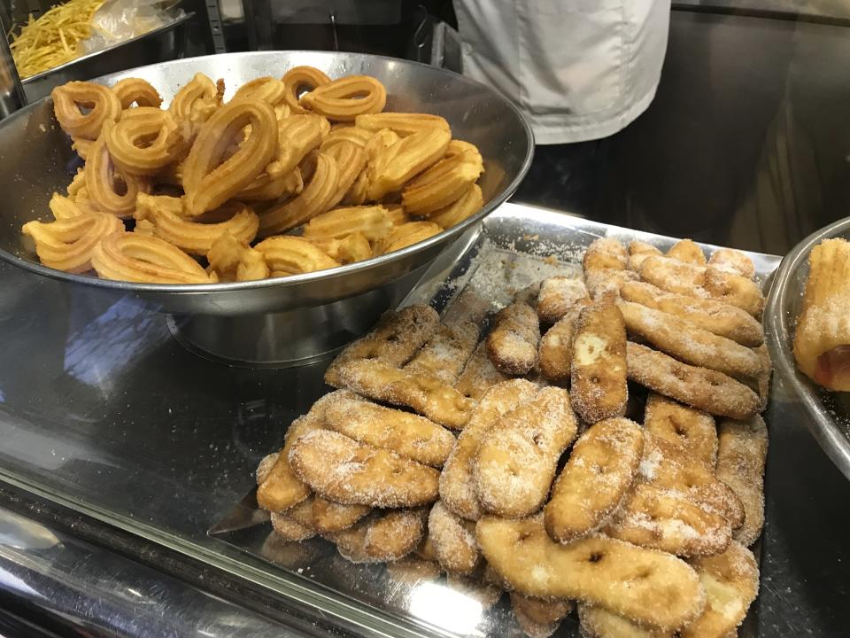This Oct. 7, 2019 photo shows churros and other fried treats on display at Xurreria, a small shop famous for its churros and chocolate, in the Gothic Quarter of Barcelona, Spain. If you’re taking a solo trip for the first time, a European city like Barcelona is a good place to start. The city is dynamic, the streets and cafes are always packed, it’s safe to walk around at night and people mostly speak English. (Courtney Bonnell via AP)