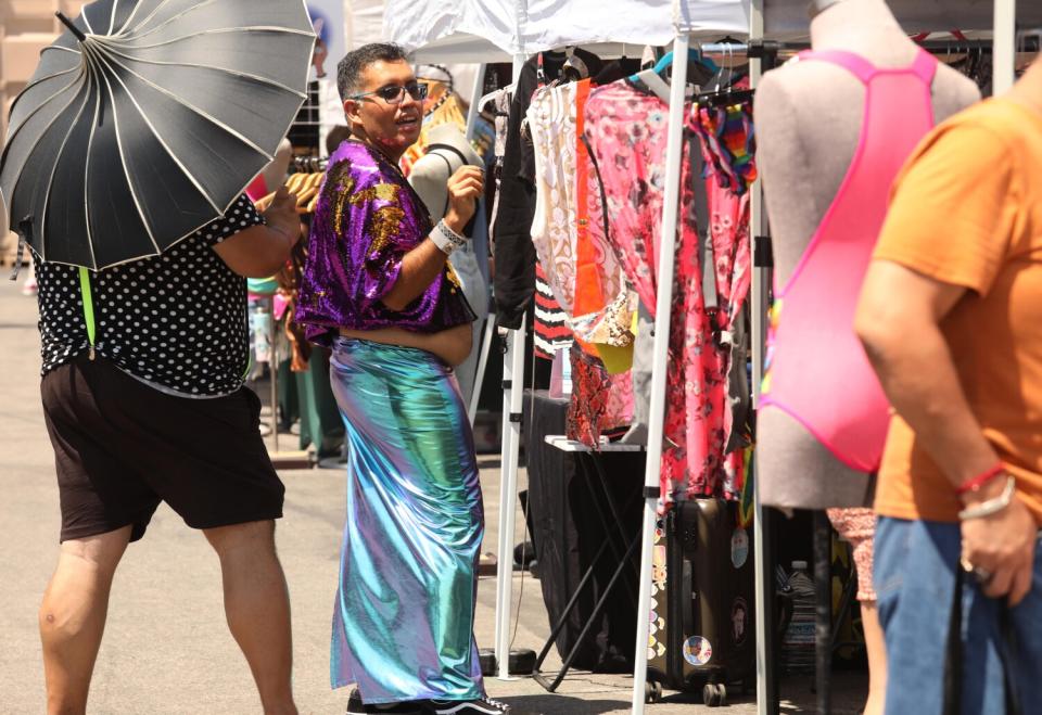 Juan Ortiz, center, with his husband Robert Ortiz, left, attend the Queer Mercado.