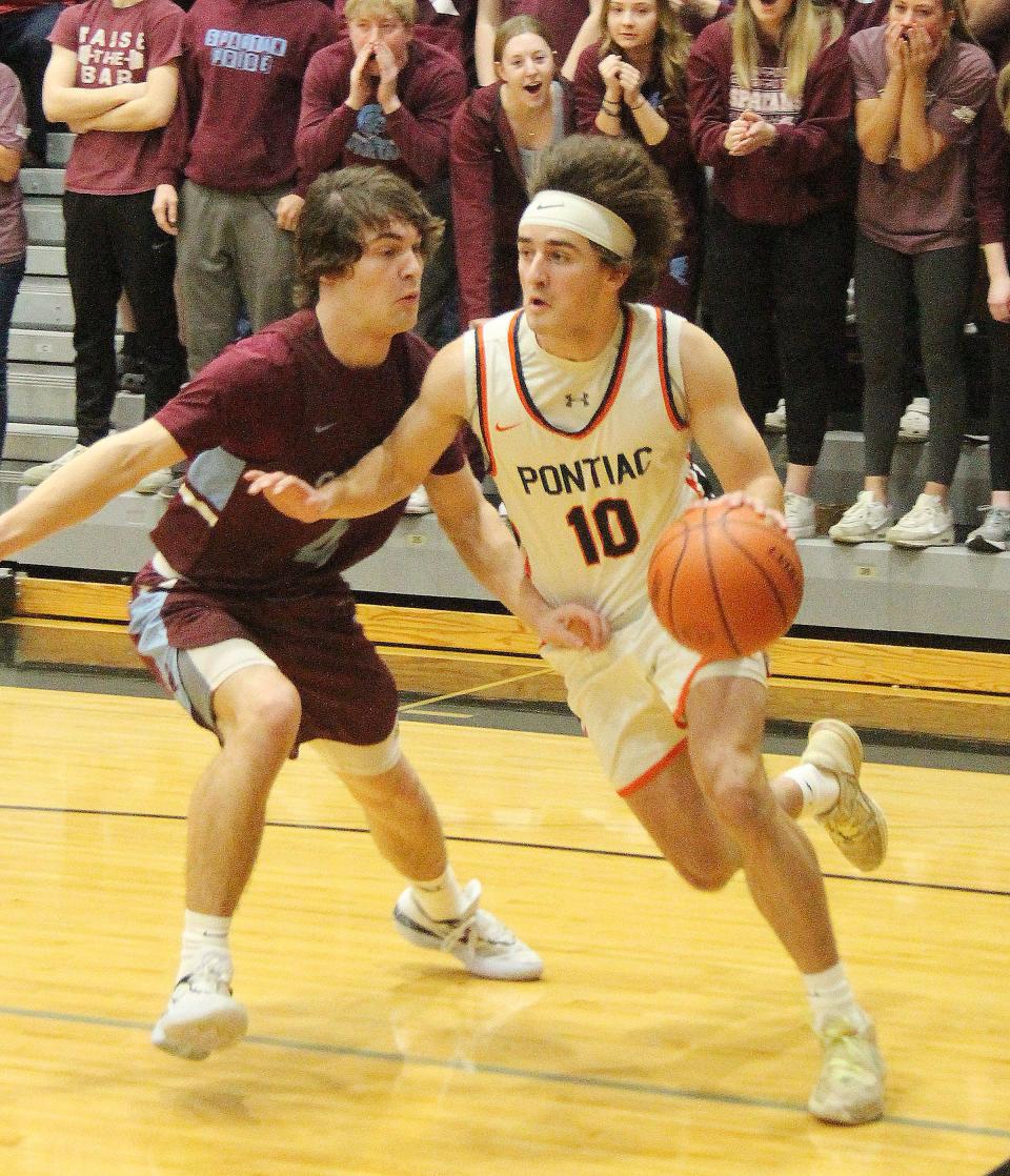 Pontiac junior Michael Kuska drives against St. Joseph-Ogden defender Tanner Jacob Tuesday. Kuska hit a 3-pointer at the end of the first half to give the eighth-ranked Indians the lead for good in what became a 55-40 win over the sixth-ranked Spartans.