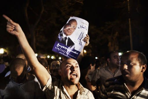 Supporters express their anger outside the ransacked headquarters of presidential candidate Ahmad Shafiq in Cairo