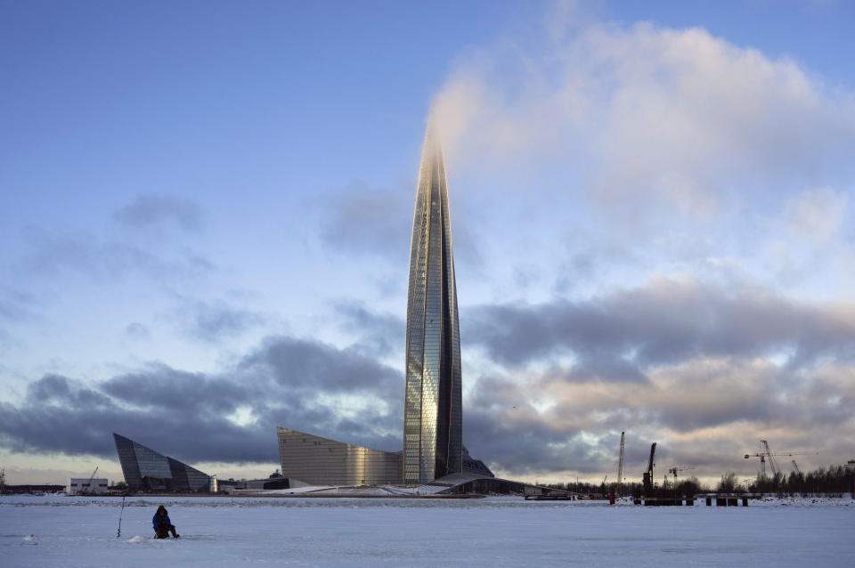 FILE- A man fishes on the ice of Finnish Gulf next to the business tower Lakhta Centre, the headquarters of Russian gas monopoly Gazprom covered by clouds in St. Petersburg, Russia, on Jan. 13, 2022. Polish and Bulgarian leaders have accused Russia of using gas supplies to blackmail their countries. The accusations come after the Russian energy Giant abruptly told them on Tuesday, that it would cut off gas to the two European nations on Wednesday, April 27, 2022 for refusing to pay for their supplies in rubles. (AP Photo/Dmitri Lovetsky, file)