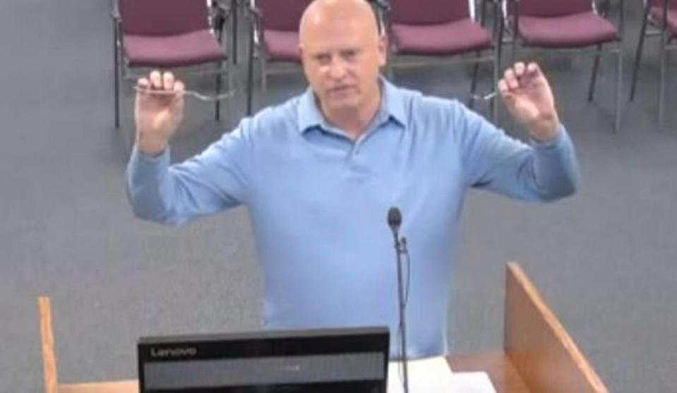 Harold Schumacher, a Union County resident, uses spoons while talking about fluoride to Stanly County Board of Commissioners meeting on March 4, 2024.