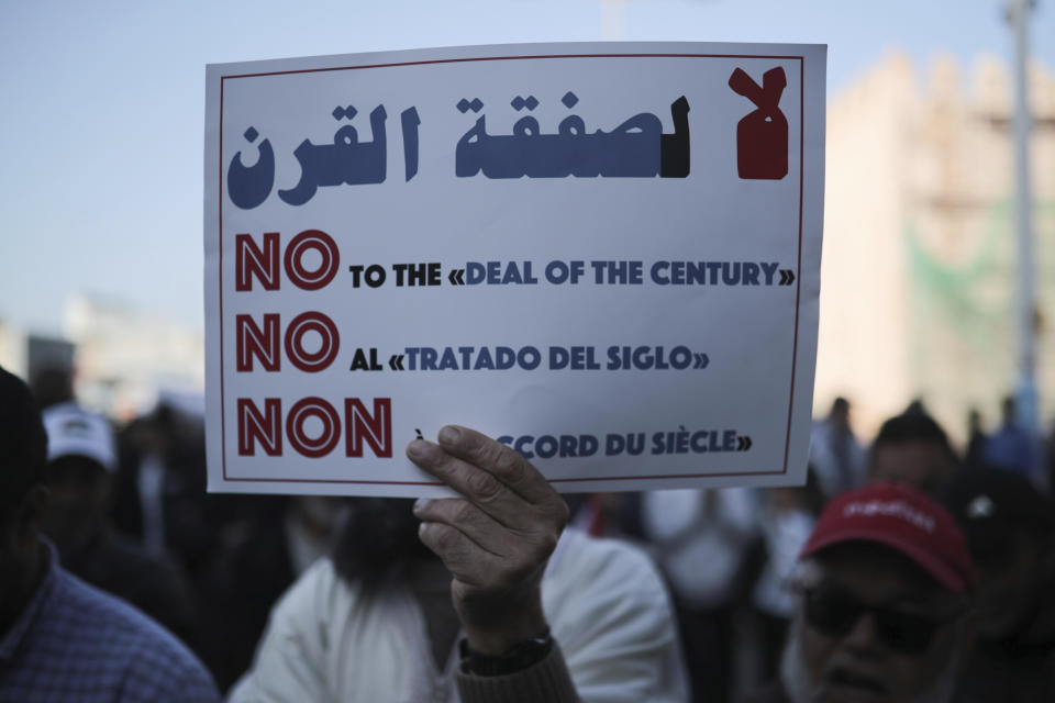 A man hold up a banner, during a demonstration in Rabat, Morocco, Sunday, Feb. 9, 2020. Thousands of Moroccans took part in a march rejecting Trump's Middle East peace plan and in support of Palestinians. Banner in Arabic reads "Down with the deal of the century". (AP Photo/Mosa'ab Elshamy)