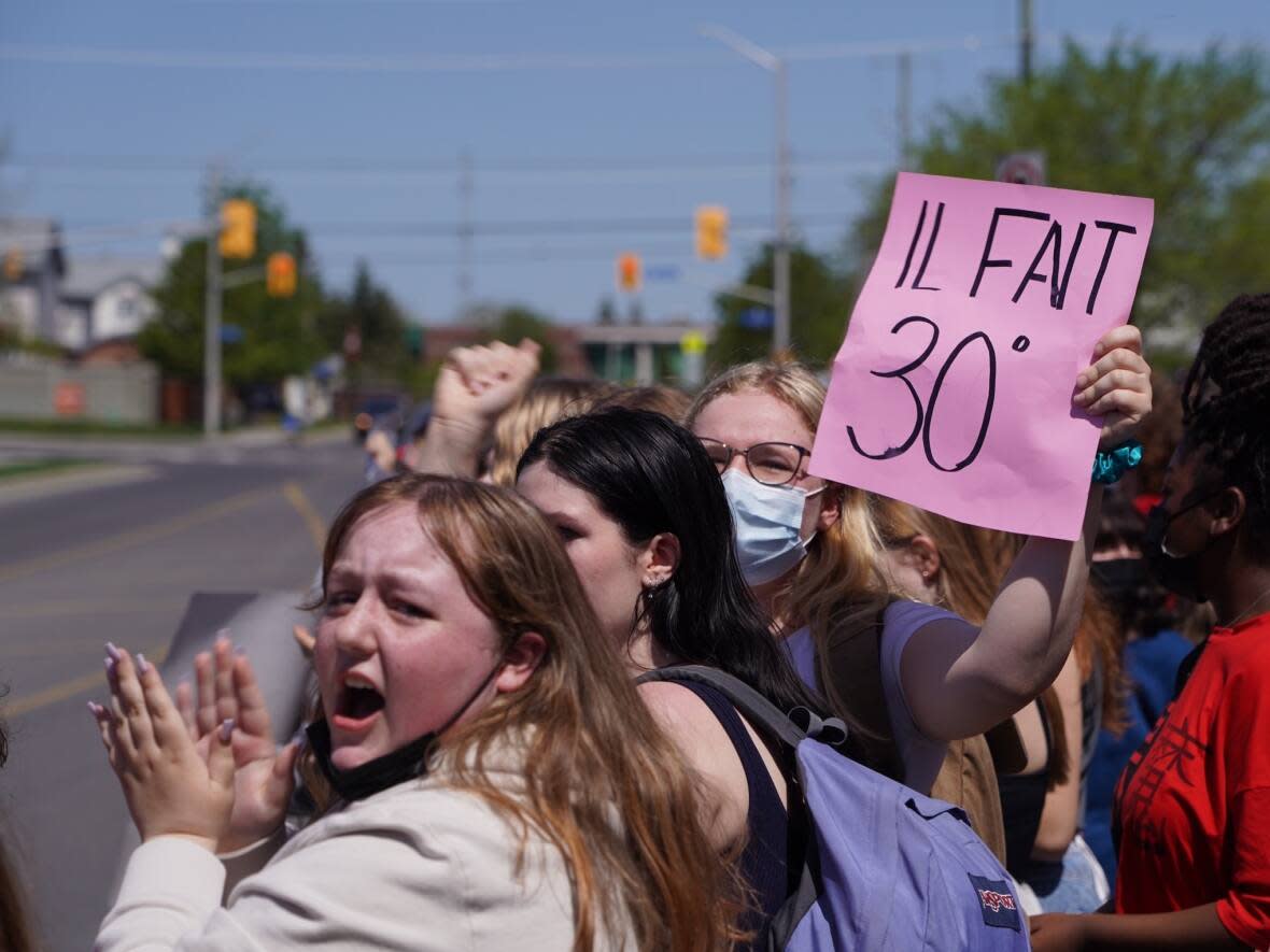 Students protested outside École secondaire catholique Béatrice-Desloges in Orléans on Friday, May 13, 2022, one day after a dress code enforcement blitz during high temperatures. The school board released its updated dress code policy Friday. (Francis Ferland/CBC - image credit)