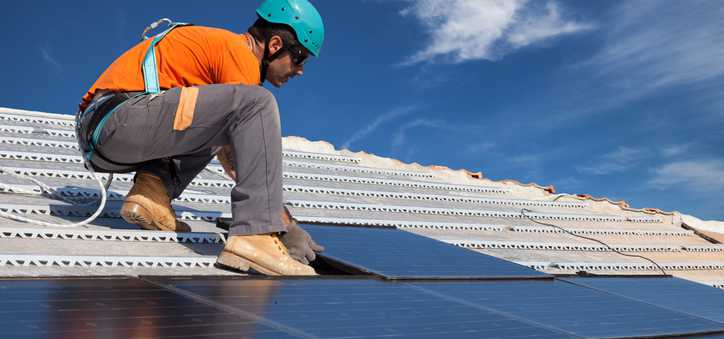 Man installing solar panels on a roof.