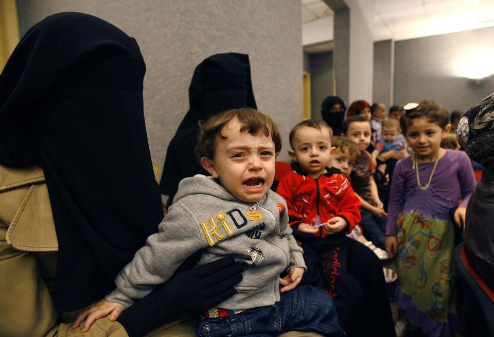 FILE - In this Thursday, Nov. 7, 2013 file photo, veiled Syrian women wait with their children for vaccinations against polio at one of the Syrian refugee camps in the southern port city of Sidon, Lebanon. An international charity organization Save Children has warned Monday, March 10, 2014 of a health care disaster in Syria with newborns dying in hospital incubators during power cuts and children having their limbs amputated for lack of alternative treatment. (AP Photo/Mohammed Zaatari, File)