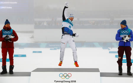 Cross-Country Skiing - Pyeongchang 2018 Winter Olympics - Men's 50km Mass Start Classic - Alpensia Cross-Country Skiing Centre - Pyeongchang, South Korea - February 24, 2018 - Gold medallist Iivo Niskanen of Finland celebrates, flanked by silver medallist Alexander Bolshunov, Olympic athlete from Russia, and bronze medallist Andrey Larkov, Olympic athlete from Russia, during the victory ceremony. REUTERS/Kai Pfaffenbach