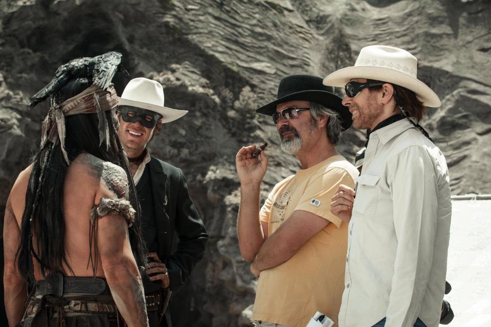 FILE - This undated publicity photo released by Disney shows, from left, Johnny Depp as Tonto, Armie Hammer as The Lone Ranger, director, Gore Verbinski and producer, Jerry Bruckheimer, on the set of "The Lone Ranger." The film opens nationwide on July 3, 2013. (AP Photo/Disney, Peter Mountain, File)