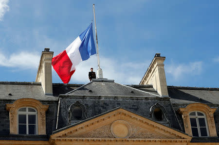 A Republican Guard pays respects after lowering the French national flag at half-mast at the Elysee Palace in Paris, France, July 15, 2016, the day after the Bastille Day truck attack in Nice. REUTERS/Philippe Wojazer