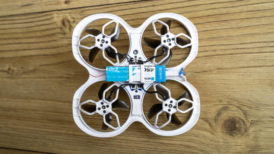 Underside of BetaFPX Cetus X drone on wooden table showing the battery