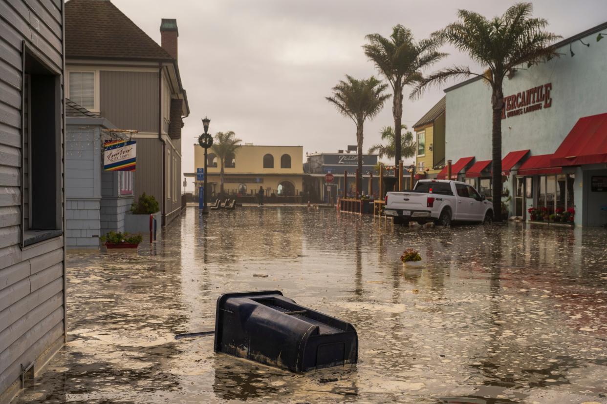 The streets are flooded in Capitola, Calif., Thursday, Dec. 28, 2023. Powerful surf is rolling onto beaches on the West Coast and Hawaii as a big swell generated by the stormy Pacific Ocean pushes toward shorelines.